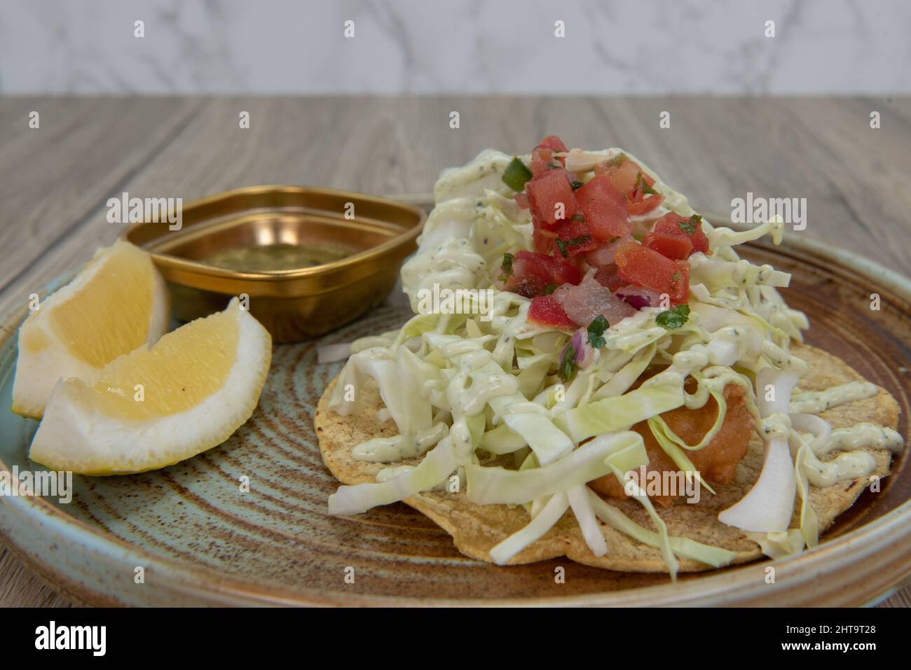 taco pastellato di birra di merluzzo impilato alto con pesce impanato e arlata di cole. Foto Stock