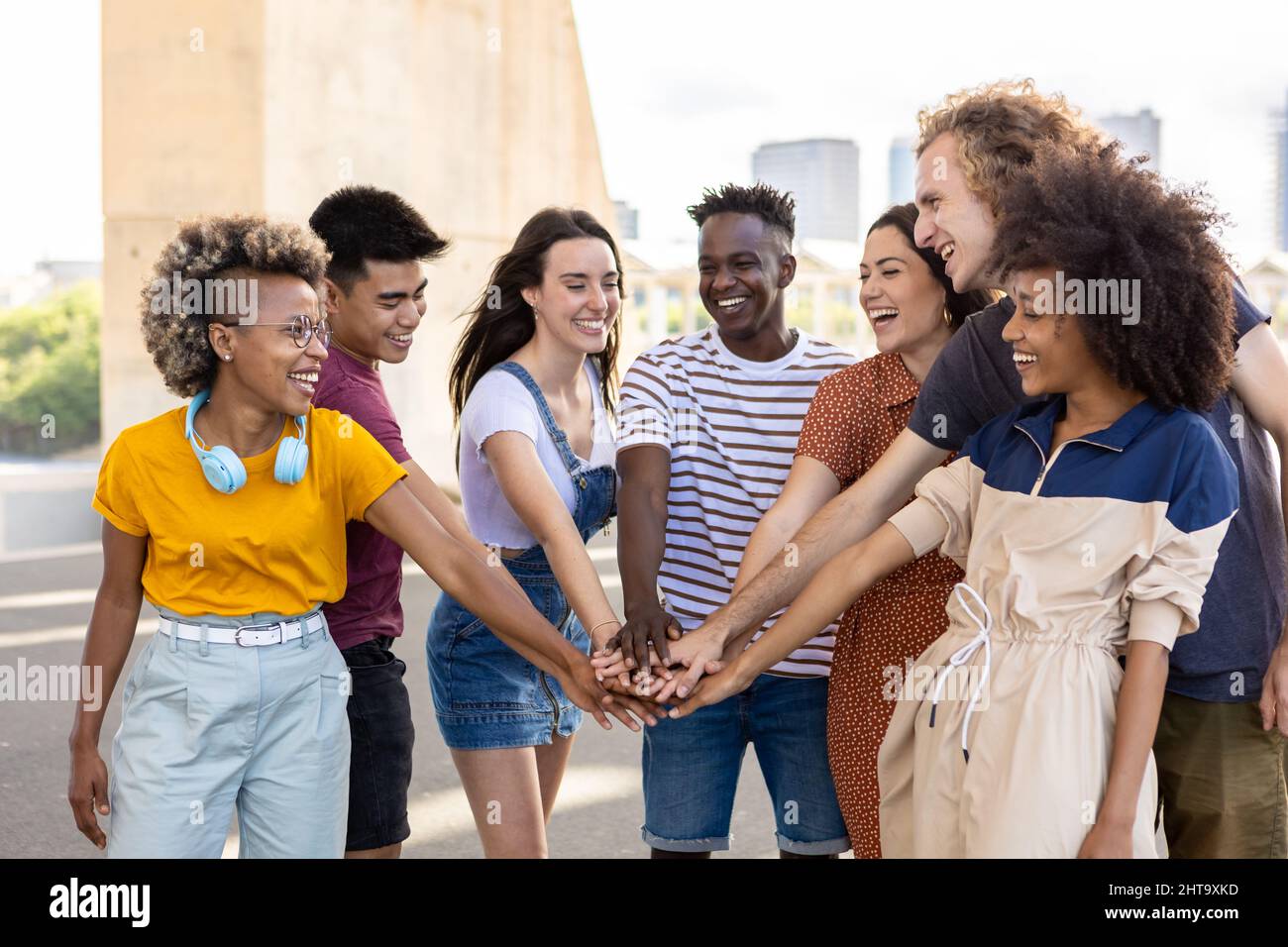 Gruppo di giovani studenti amici con le mani in pila che mostrano l'unità internazionale Foto Stock