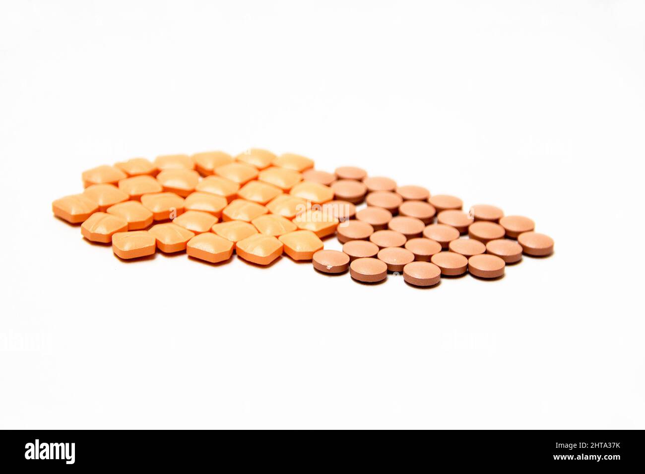 Mucchio di pillole medicinali rosa e marrone isolato su sfondo bianco Foto Stock