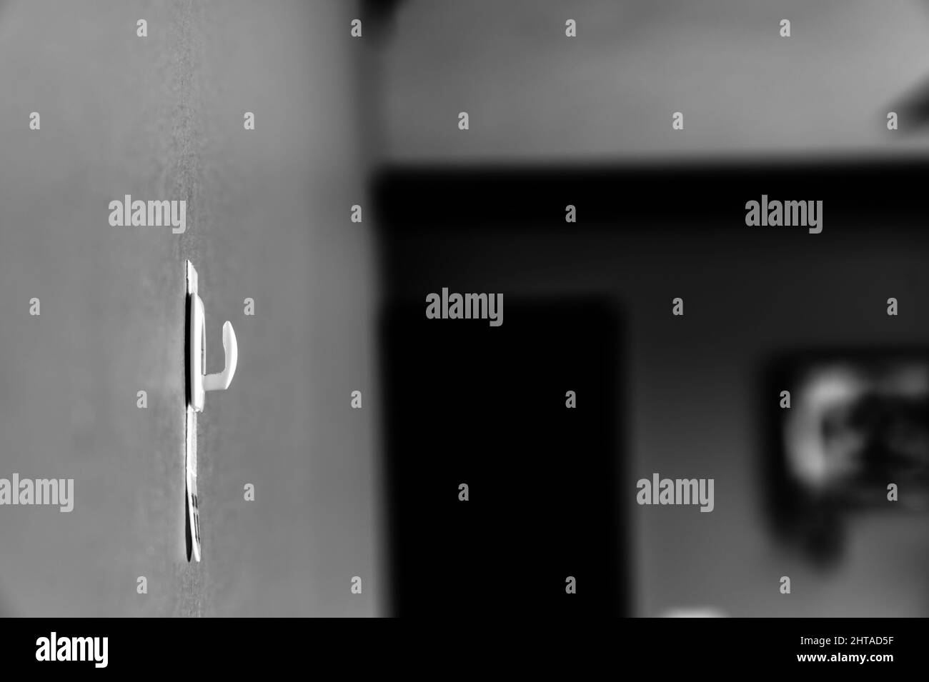 Messa a fuoco selettiva sulla staffa a parete della striscia adesiva che può essere rimossa tirando il nastro Foto Stock