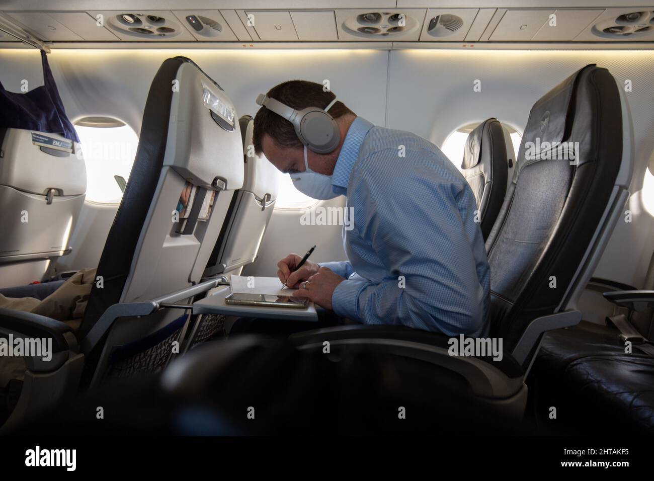 Persona che indossa una maschera facciale e lavora sull'aereo Foto Stock