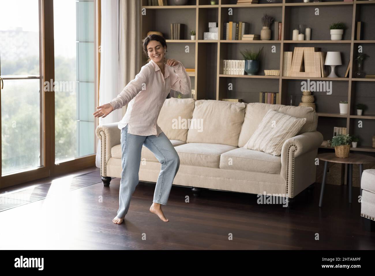 Felice spensierata donna ispanica che balla a casa. Foto Stock