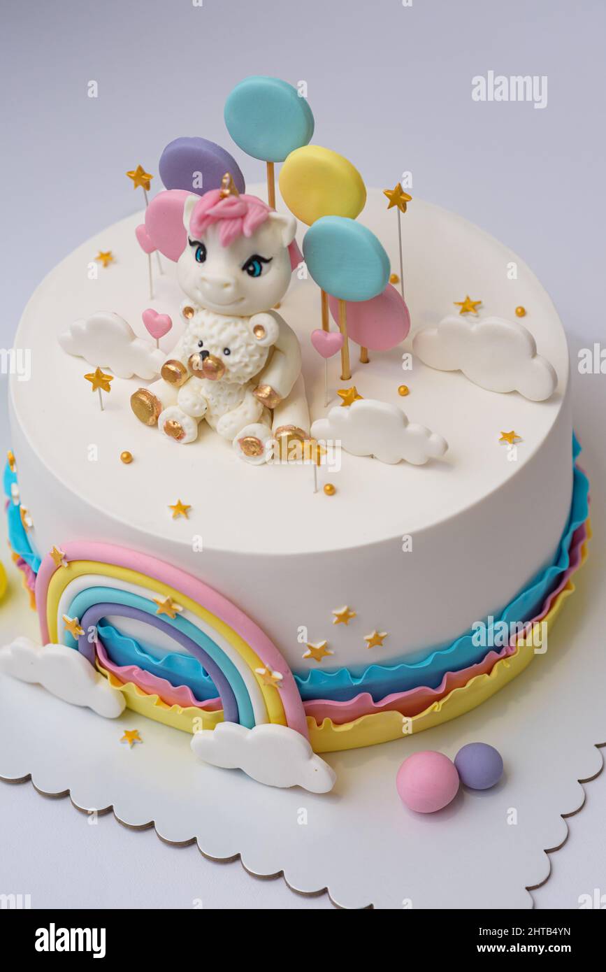 Foto di un disegno di torta unicorno con arcobaleno su sfondo bianco Foto Stock