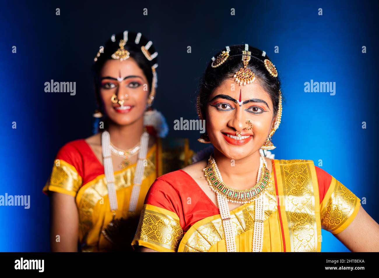 Sorridenti ballerini Bharatnatyam sul palco - concetto di ballerini clascali indiani, intrattenimento e cultura tradizionale. Foto Stock