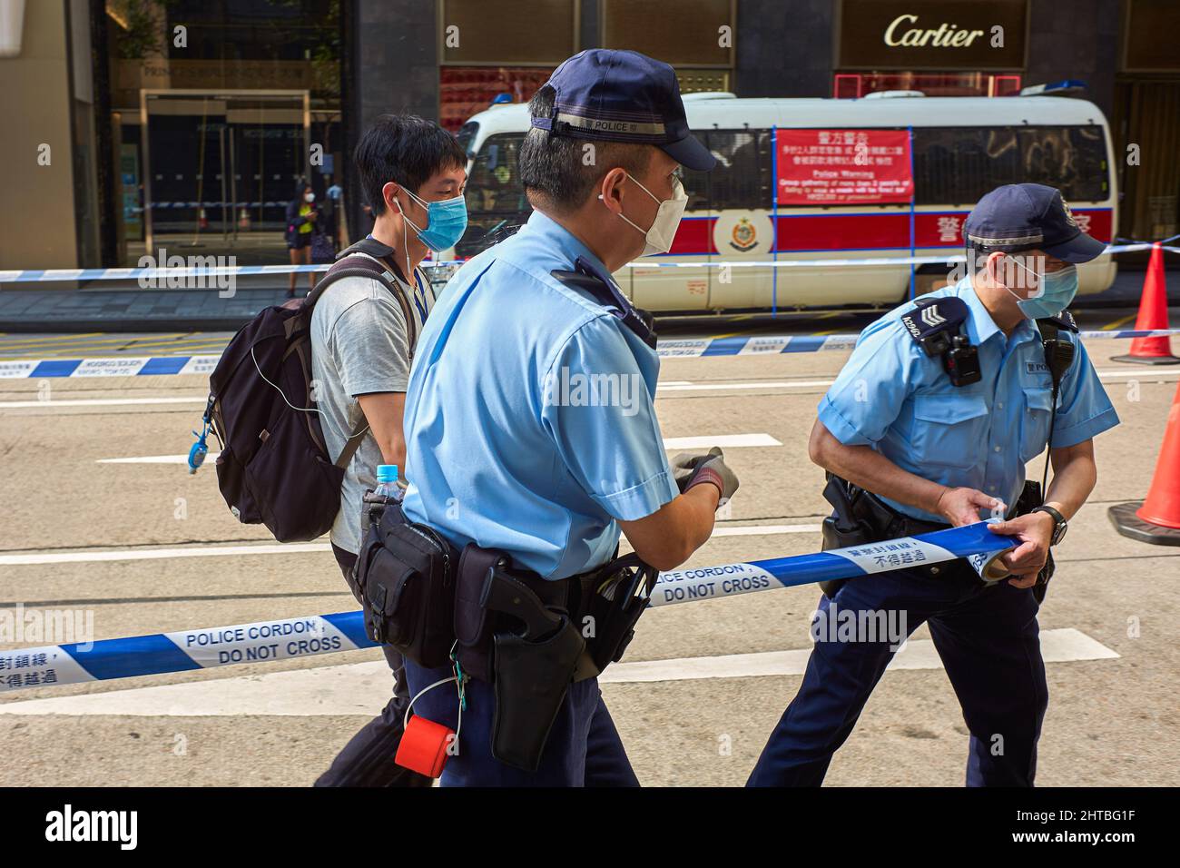 Hong Kong, Cina. 27th Feb 2022. I funzionari di polizia hanno stabilito un cordone durante un'operazione contro le persone che non rispettano le misure di allontanamento sociale nel distretto centrale di Hong Kong. Hong Kong sta inasprendo le regole di distanziamento sociale per contrastare la peggiore ondata epidemica, imponendo l'uso di maschere all'esterno in tutte le circostanze e raduni limitati a due persone. (Foto di Emmanuel Serna/ SOPA Images/Sipa USA) Credit: Sipa USA/Alamy Live News Foto Stock