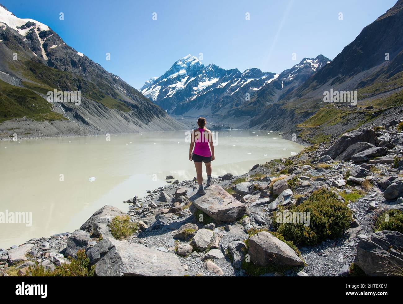 Una donna caucasica che guarda alla distanza nella valle di Hooker che conduce al Monte Cook di Aoraki in Nuova Zelanda Foto Stock
