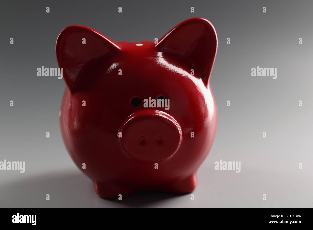 Contenitore rosso piggybank sulla superficie grigia, cosa per risparmiare denaro, animale in ceramica Foto Stock