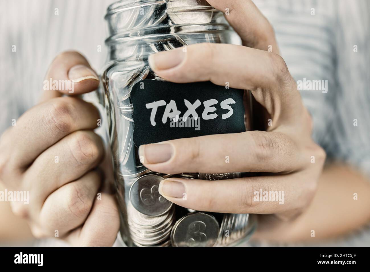 La donna tiene deduzione delle tasse in vaso di vetro. Foto Stock