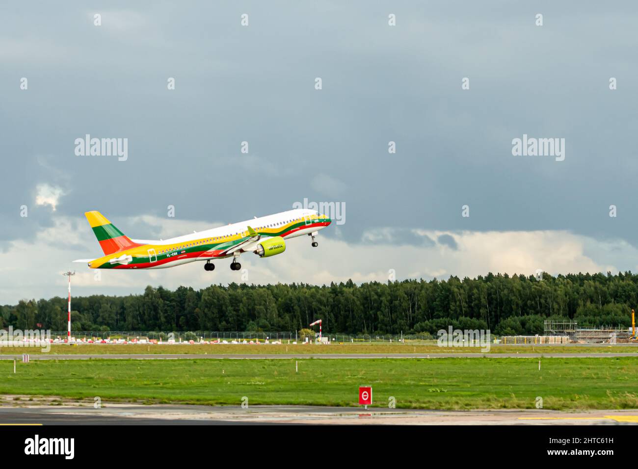 Riga, Lettonia - 19 agosto 2021: AirBaltic Airbus A220-300 YL-CSK aereo nei colori della bandiera lituana decollo dall'aeroporto RIX Foto Stock