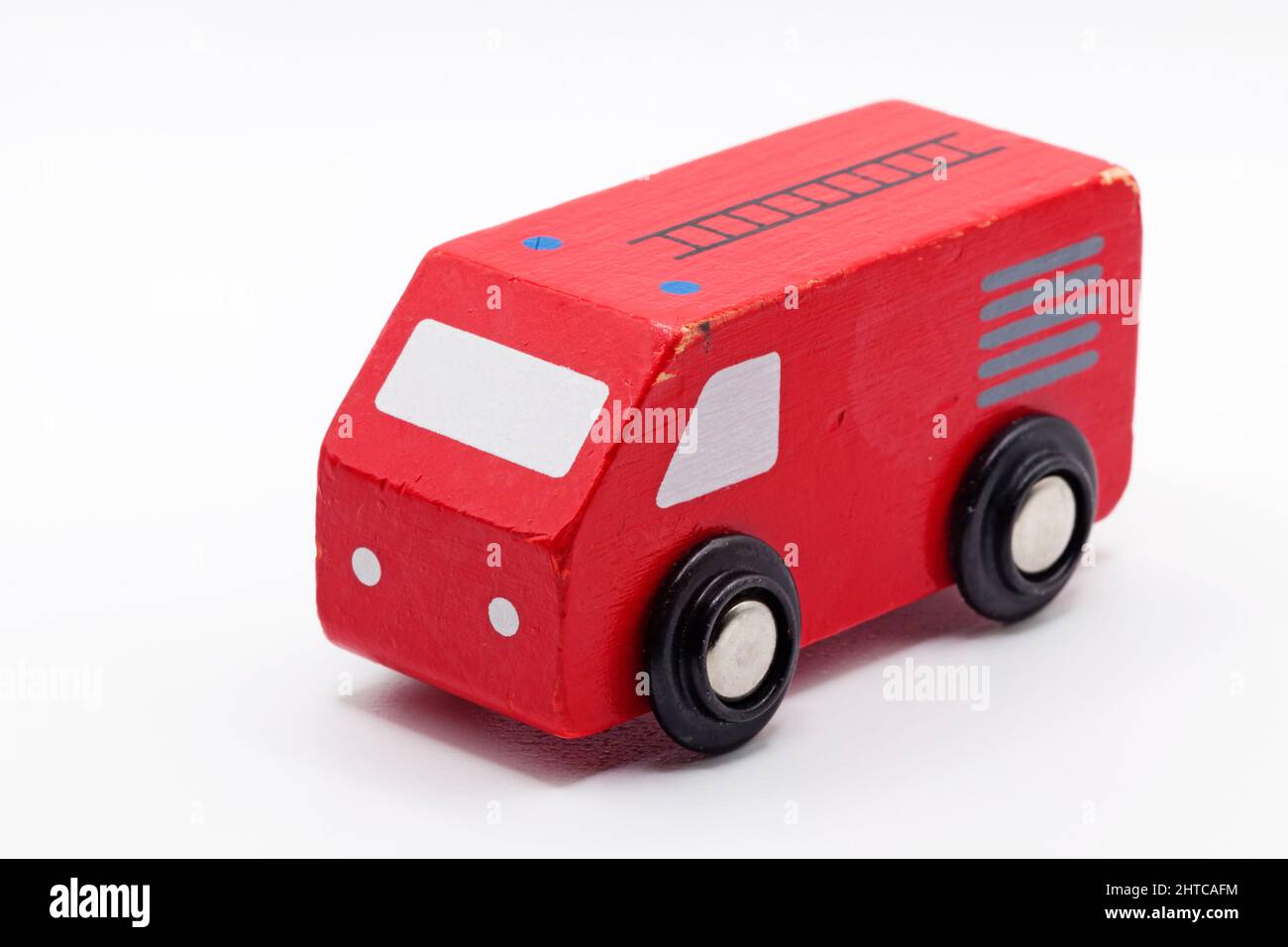 un'auto giocattolo rossa in legno su sfondo bianco Foto Stock