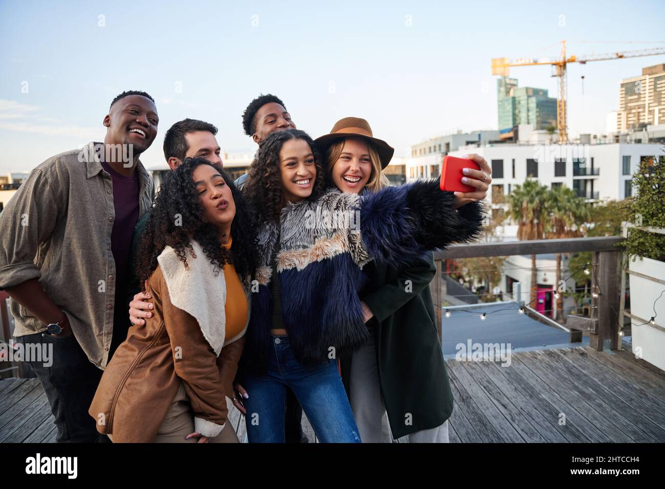 Gruppo multiculturale di amici che prendono un selfie in una festa sul tetto. Posa con giovani amici adulti. Foto Stock