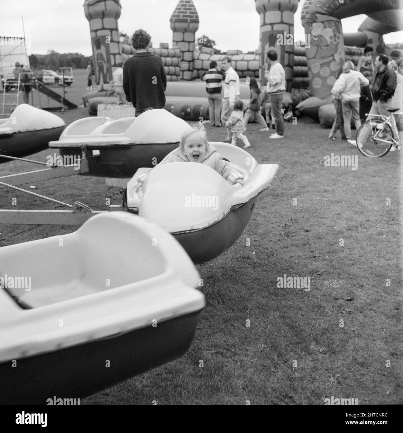 Laing Sports Ground, Rowley Lane, Elstree, Barnet, Londra, 11/06/1988. Un bambino piccolo che si gode il giro allegro-go-round al Family Day 1988 al Laing's Sports Ground. Le attrazioni del Family Day di quell'anno sono incluse: Una sfilata di auto d'epoca, giri in elicottero, sbattimento dei piatti, bancarelle, una competizione in stile "IT's a Knockout" e tornei di tennis e calcetto. L'evento è stato aperto da John Conteh, ex campione mondiale di pesi leggeri e si è concluso con un barbecue e una discoteca. Foto Stock