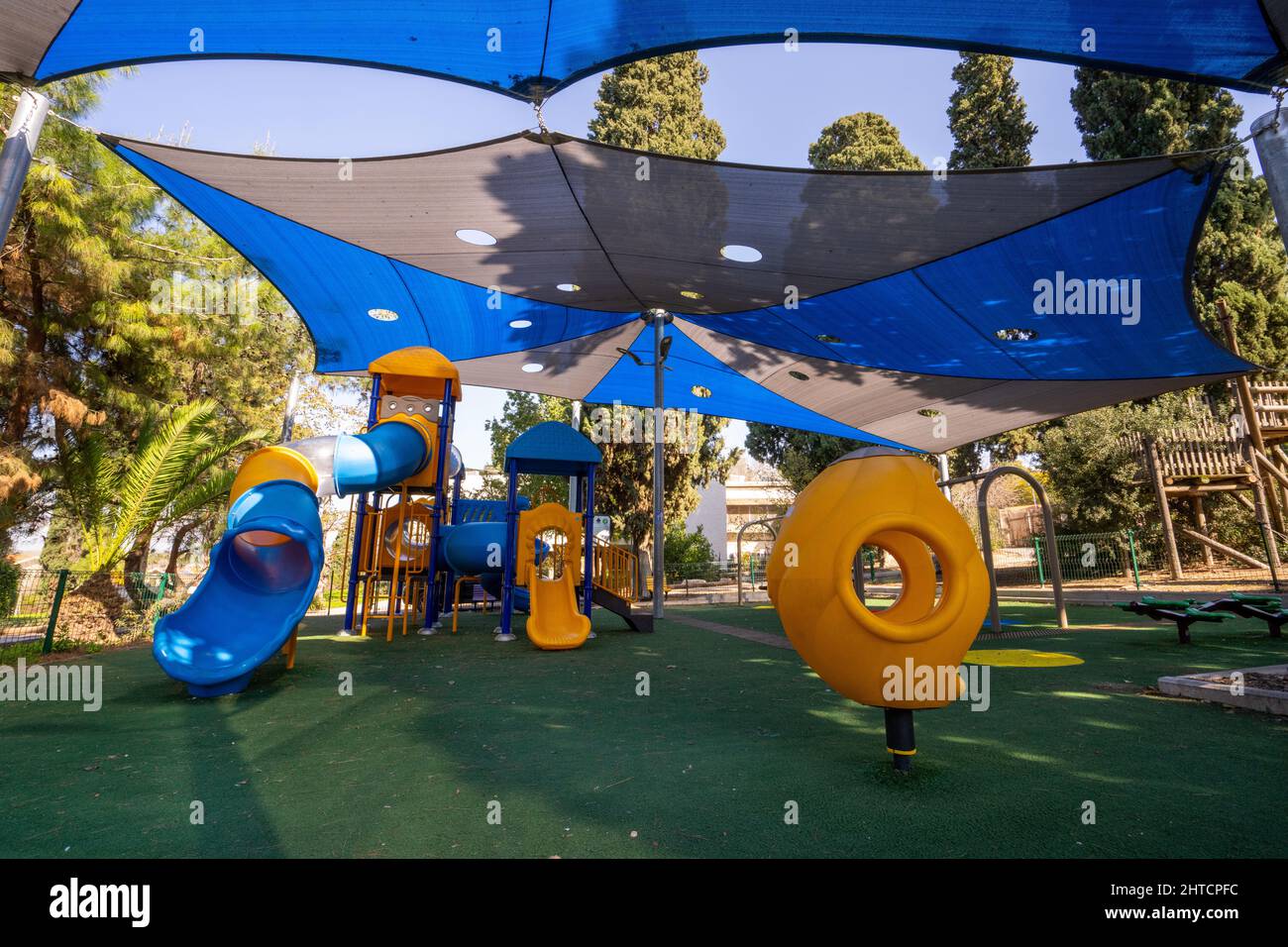Parco giochi pubblico ombreggiato locale per bambini. Fotografato in Israele Foto Stock