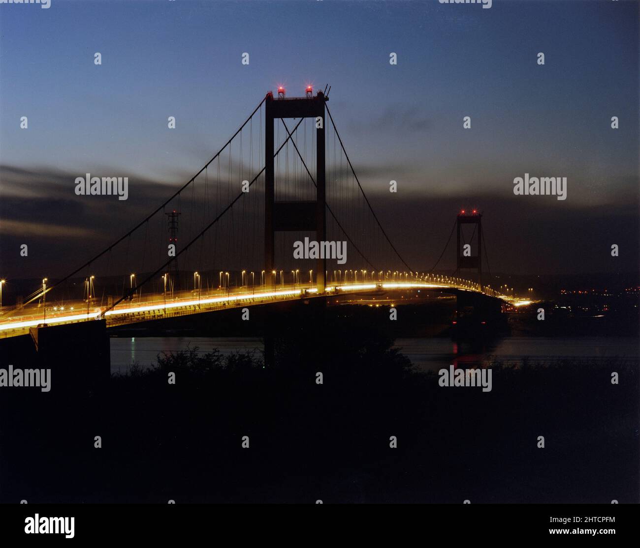 Severn Bridge, M48, Aust, South Gloucestershire, 10/11/1987. Il ponte Severn si illuminava di notte, visto durante il lavoro di rafforzamento svolto da Laing. Il progetto e la costruzione originali del ponte Severn avevano inferiore al volume stimato di traffico dal suo completamento nel 1966 e, pur essendo stato costruito per durare 120 anni, è stato trovato che richiedeva interventi di riparazione dopo solo il 20. Laing Industrial Engineering &amp; Construction ha vinto il contratto &#XA3;29,5m del Dipartimento dei Trasporti e il rafforzamento dei lavori su tutti gli elementi della struttura è iniziato nel maggio 1987. Il progetto è stato completato nell'aprile 1990 in t Foto Stock