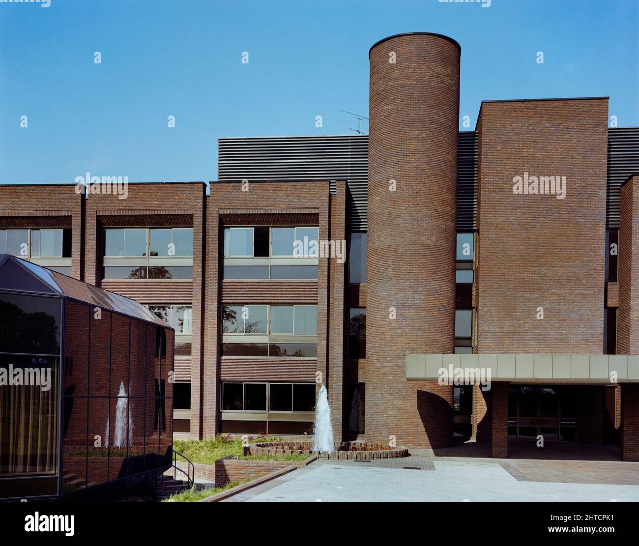 Sir John Laing Building, Page Street, Mill Hill, Barnet, Londra, 18/05/1981. L'esterno dell'ingresso anteriore al Sir John Laing Building, Mill Hill, che mostra il Centro Congressi di vetro ottagonale sulla sinistra. Il Sir John Laing Building, nominato in onore del presidente della società, morto nel gennaio 1978 all'età di 98 anni, è stato costruito tra il 1977 e il 1980, come previsto dal 1974. L'edificio ha completato una fase di sviluppo presso il complesso della sede di Mill Hill di Laing, un'area che l'azienda aveva occupato da quando si era spostata da Carlisle nel 1922. Entro il 1988, tuttavia, si tratta di un'importante ristrutturazione del Foto Stock