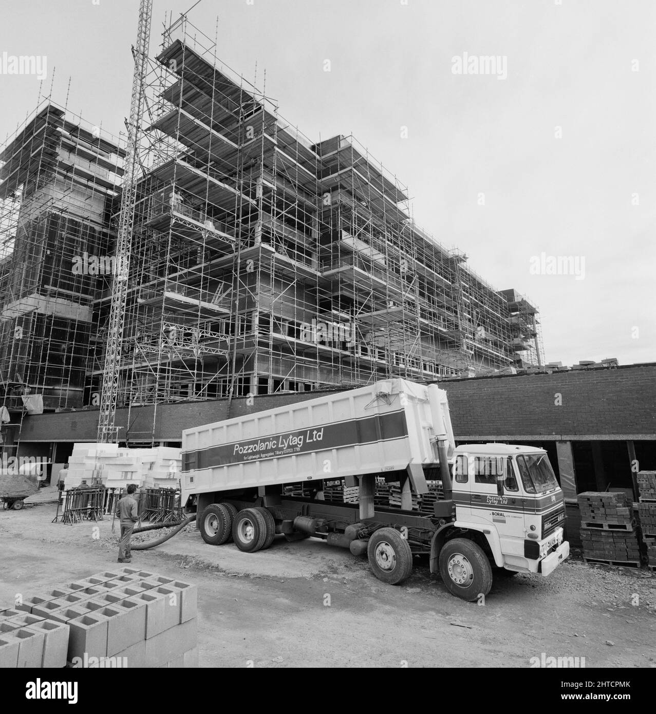 St George's Hospital, Blackshaw Road, Tooting, Wandsworth, Londra, 07/08/1985. Un autocarro che fornisce aggregato leggero al cantiere di St James Wing presso il St George's Hospital, Tooting. 'Lytag' era un aggregato leggero prodotto da ceneri combustibili polverizzate provenienti da centrali elettriche e utilizzato in materiali da costruzione in calcestruzzo. Lytag Ltd ha sviluppato il prodotto nel 1961 ed è stata una filiale di John Laing Ltd fino al 1982, quando è stato acquistato da pozzolanic Ltd. Pozzolanic Ltd è stato a sua volta acquistato dal GRUPPO DORAL, come dimostrato dalla livrea del camion. Foto Stock