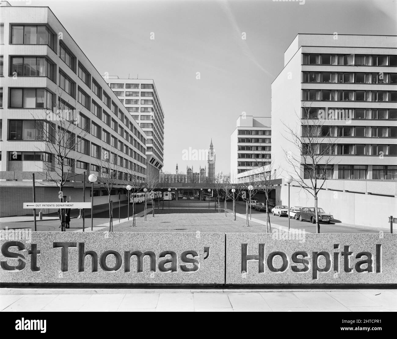 St Thomas' Hospital, Lambeth Palace Road, Lambeth, Londra, 28/02/1977. Guardando lungo il viale centrale tra quattro nuovi isolati al St Thomas' Hospital, con l'insegna dell'ospedale in primo piano, da est. I lavori sulla fase II di un progetto di ricostruzione presso l'Ospedale St Thomas sono stati intrapresi da Laing e iniziati all'inizio del 1969 e completati nel 1975. Questa fase includeva un nuovo blocco di reparto, suite operative, reparto ambulatorio, istituto di ricerca, casa degli infermieri e scuola di formazione degli infermieri. La fase i era stata completata nel 1966 da Sir Robert McAlpine e Sons; la fase III del progetto era prevista per b Foto Stock