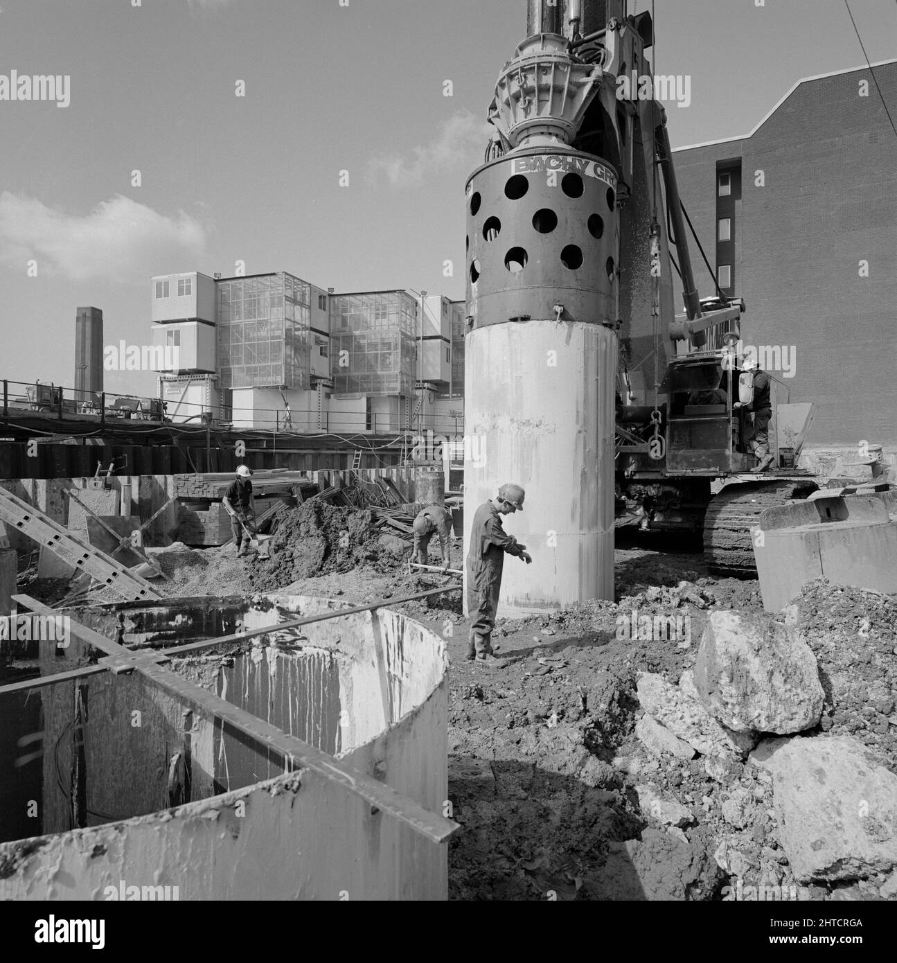 Vintners Place, Upper Thames Street, Queenhitthe, Londra, 30/08/1990. Un lavoratore che si trova di fronte all'involucro di acciaio che viene guidato in un cumulo forato nel sito di costruzione di Vintners Place. Laing ha sottoscritto il contratto di gestione &#XA3;79m per la costruzione di un ufficio di alta qualità 37.000sqm a Vintners luogo tra marzo 1989 e dicembre 1992. I lavori in loco sono iniziati nel giugno 1989 con la demolizione di 10 edifici, tra cui Vintry House e Kennett Wharf, sul lungofiume. La fa&#xe7;ade del Tamigi House lungo Queen Street Place è stata conservata e incorporata nel develo Foto Stock