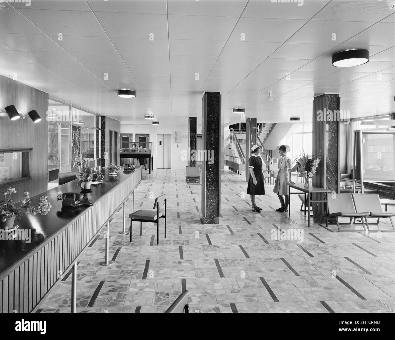 West Cumberland Hospital, Homewood Road, Homewood, Whitehaven, Copeland, Cumbria, 27/08/1964. Due infermieri che parlano nell'ingresso principale e nell'area d'attesa del West Cumberland Hospital. Foto Stock