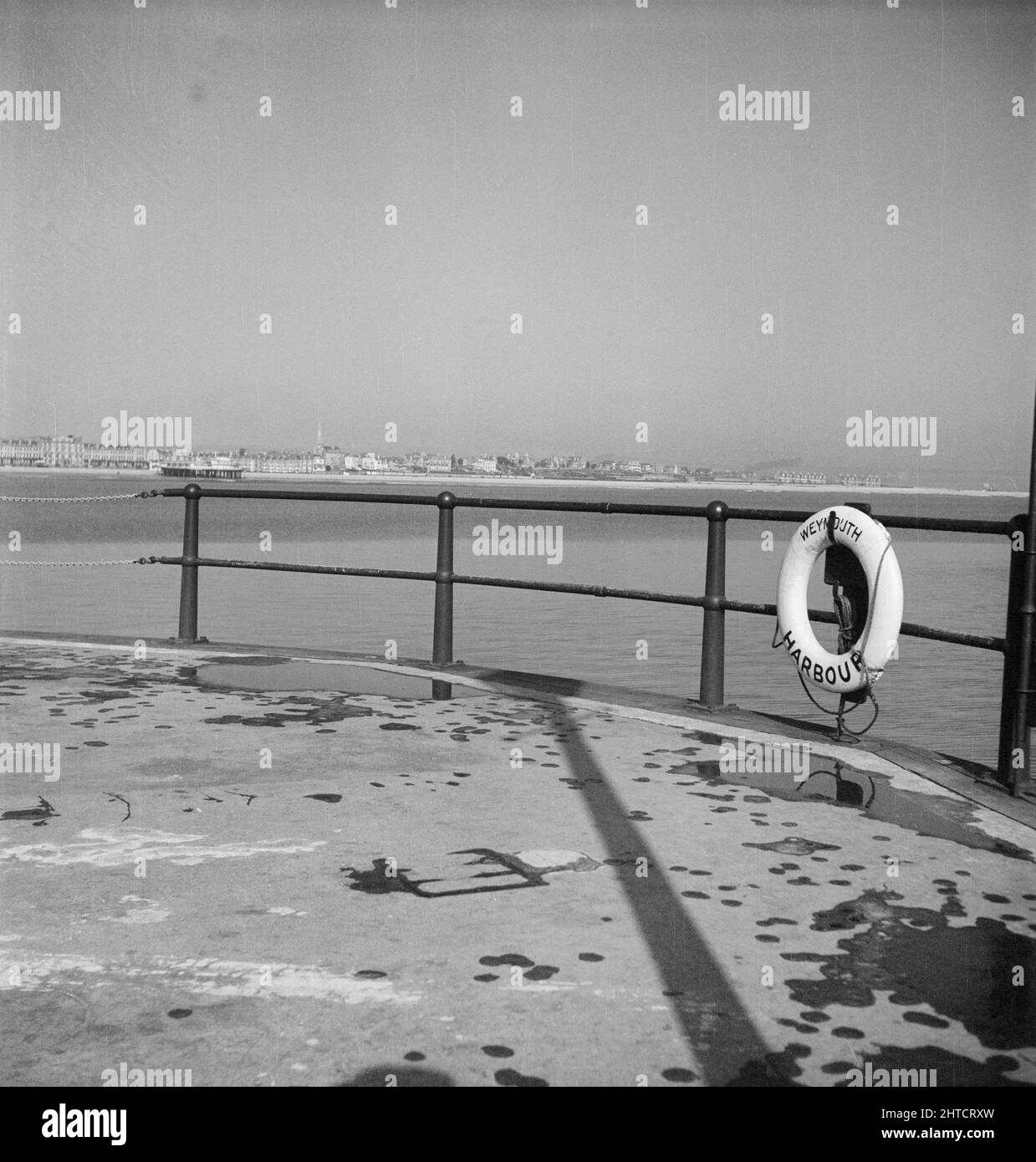 Weymouth, Weymouth e Portland, Dorset, probabilmente giu 1948. Una vista che guarda in direzione nord-ovest da vicino all'entrata del Porto di Weymouth, che mostra una boa di salvataggio in primo piano appesa alle ringhiere del molo. Questa foto è stata scattata durante una gita del personale di Laing a Weymouth. Sebbene il fotografo non abbia registrato alcuna data, è noto che nel giugno 1948 si è svolta una gita del personale. Foto Stock