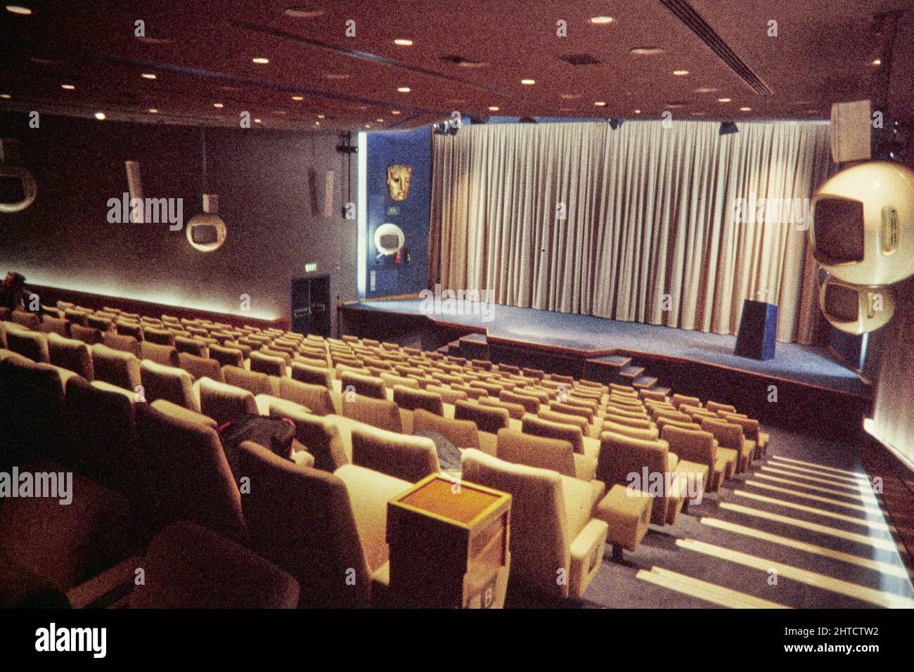 Sede BAFTA, Piccadilly, St James's, City of Westminster, Londra, 1976-1999. L'auditorium della sede BAFTA, con monitor sferici Decca sospesi lungo le pareti. Un nuovo centro per la British Academy of Film and Television Arts è stato inaugurato nel 195 a Piccadilly nel 1976. Tra il 1883 e il 1970, l'edificio ospitava il Royal Institute of Painters in Water Colors. L'architetto per la ristrutturazione del teatro, e il progettista dei monitor a colori Decca da 26" sospesi nell'auditorium, è stato Brian Perry. Foto Stock