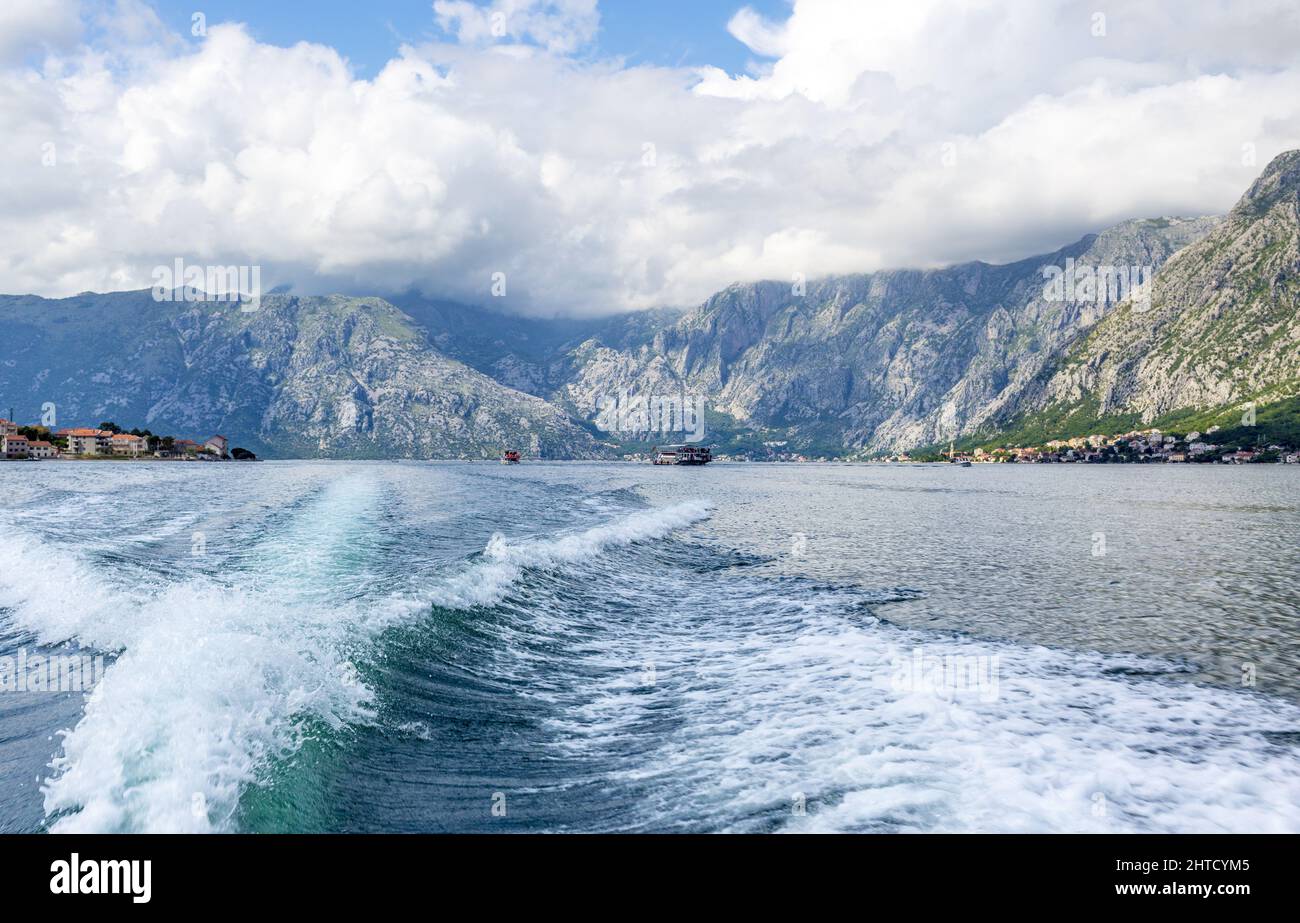 Una fantastica vista delle grandi colline con le nuvole che riposano su di loro da una gita in barca su un mare Foto Stock