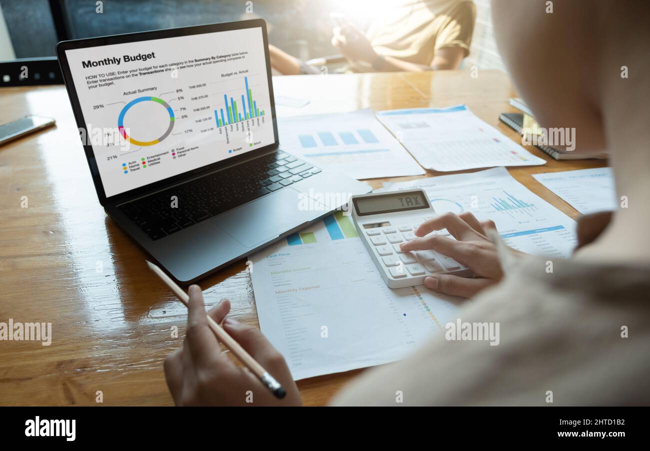 Chiudere l uomo d affari e partner utilizzando una calcolatrice e portatile per calaulating Finanza, imposte, contabilità, statistiche e analitiche concetto di ricerca Foto Stock