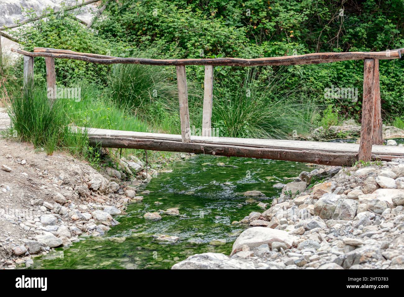 Un piccolo ponte in legno su un torrente minerale a partire dalla sorgente di acqua minerale bagni San Filippo Foto Stock