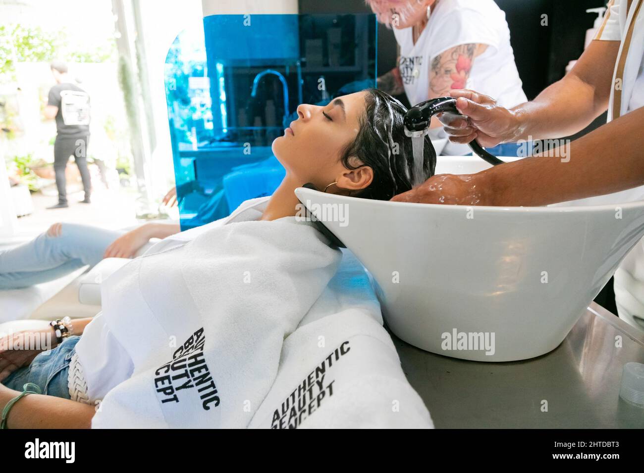 Modello femminile di capelli neri che ha i capelli lavati in un salone Foto Stock