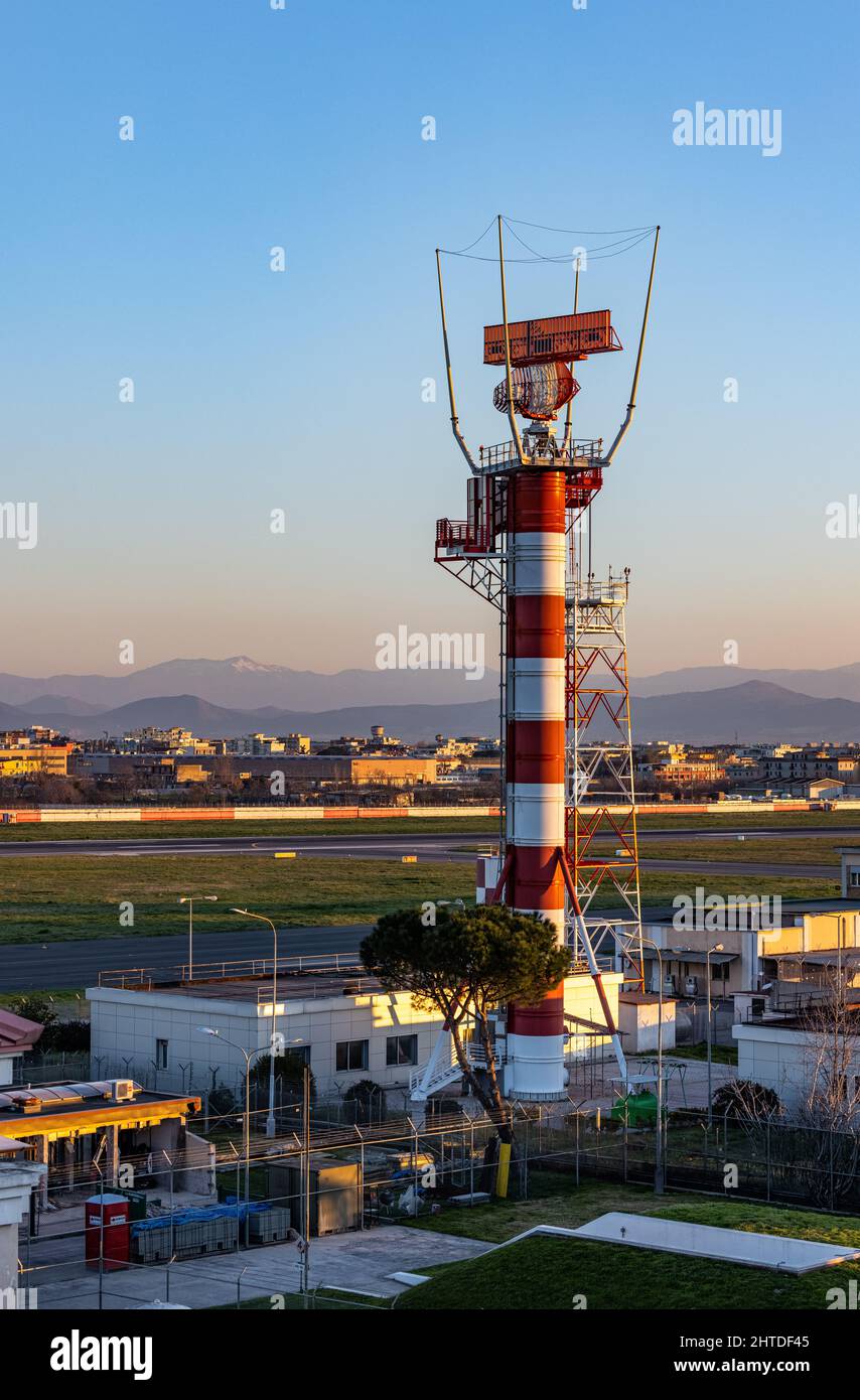 Scatto verticale di una torre radio e pista aeroportuali a strisce rosse e bianche Foto Stock