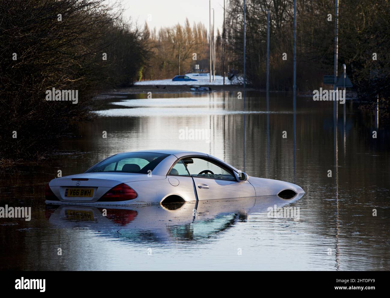 Mercedes SL bianco fino al suo punto-archi in acqua alluvione dal fiume Aire vicino Allerton Bywater, West Yorkshire, Inghilterra Regno Unito Foto Stock