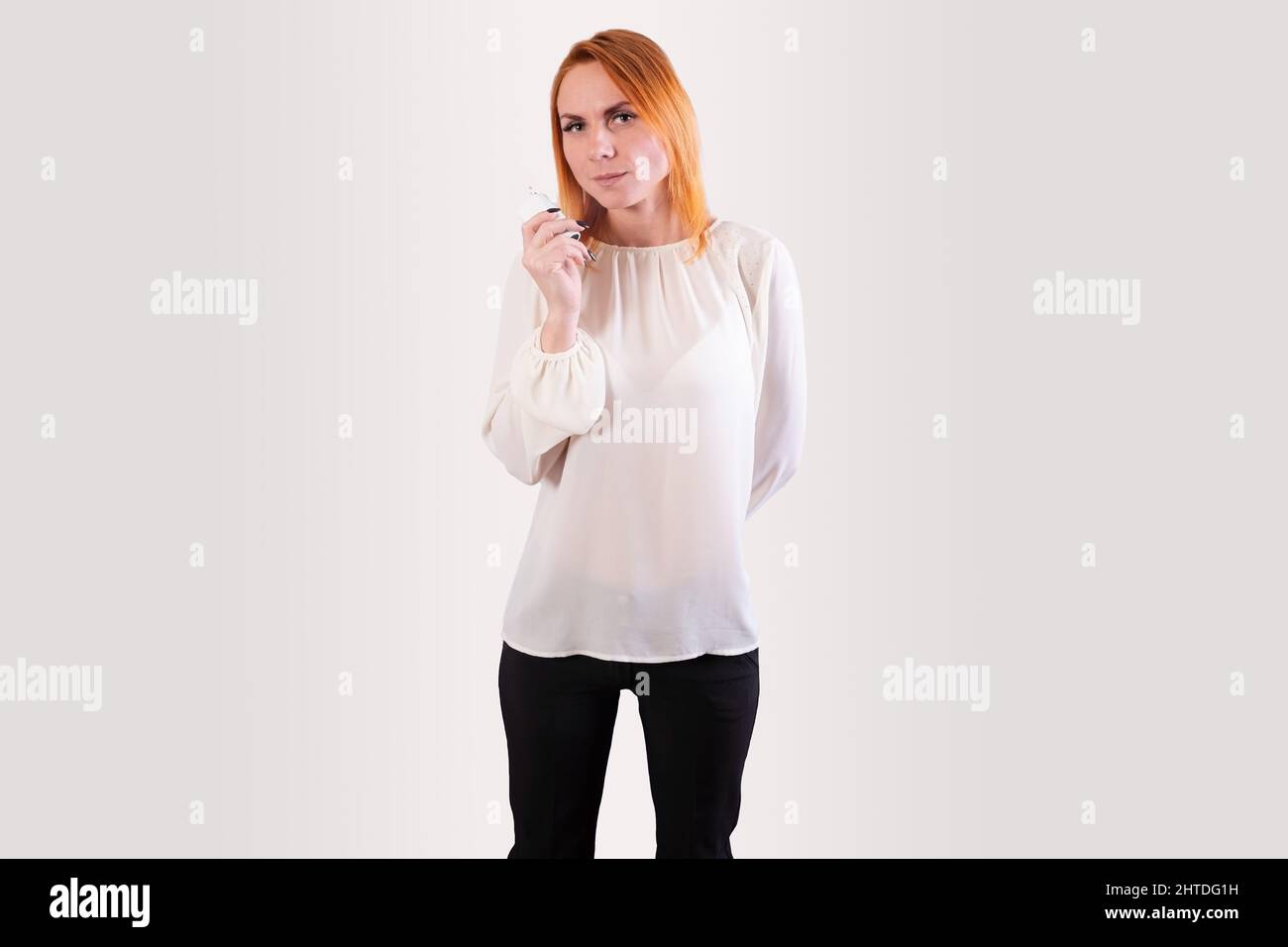 Ragazza con un riscaldatore del tabacco, su sfondo grigio. Foto Stock