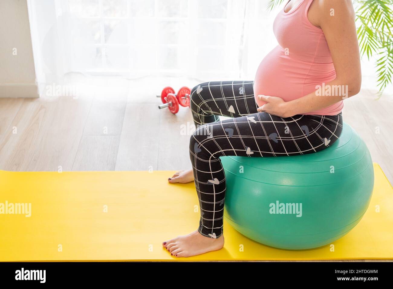 giovane donna incinta seduta su una palla fitness fa esercizi per  rafforzare il pavimento pelvico in gravidanza durante le classi di  preparazione del parto Foto stock - Alamy