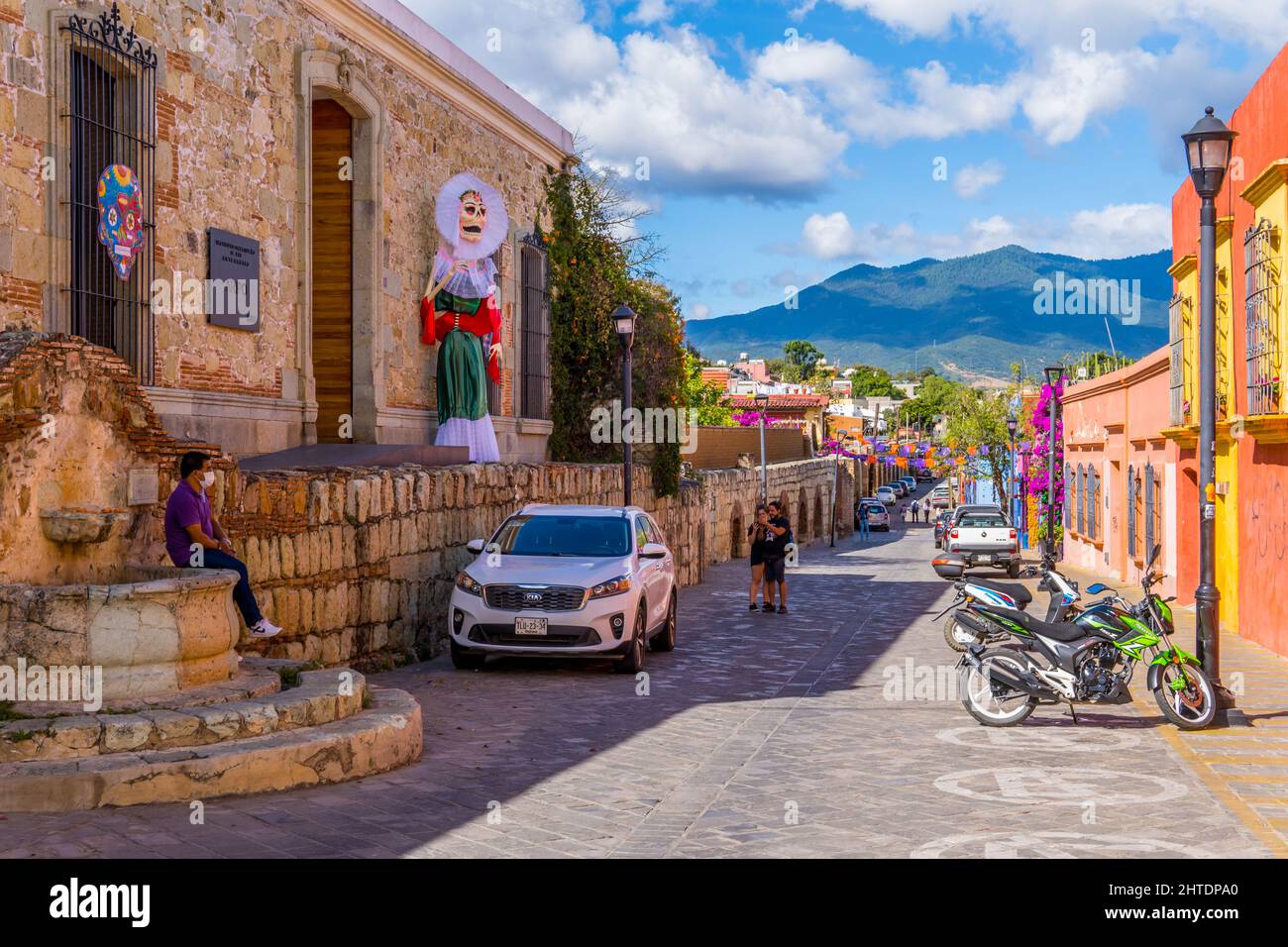 Foto di una strada con case coloniali e la statua del giorno dei morti Foto Stock