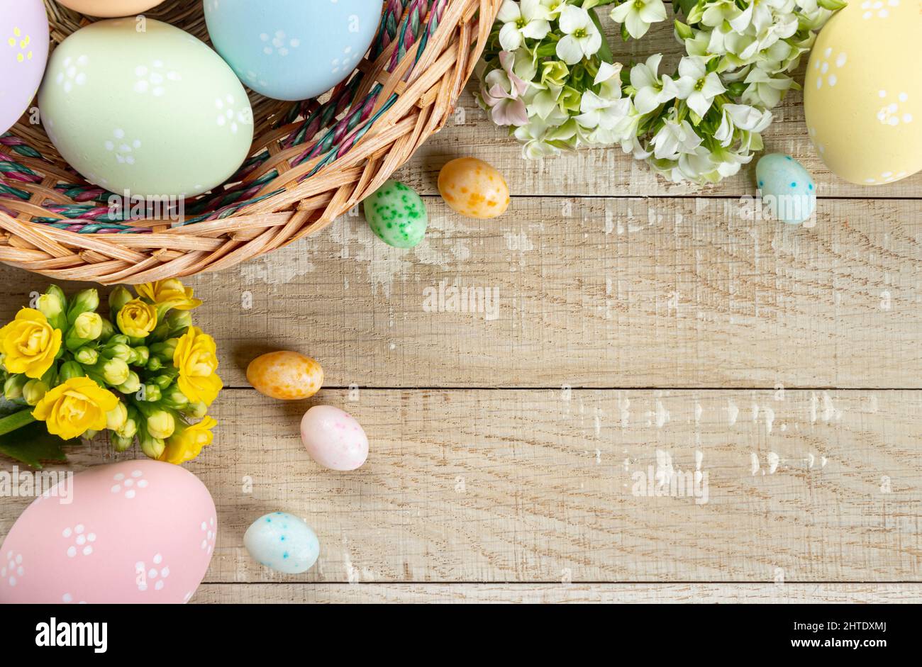 Confine di pasqua uova e fiori intorno a un rustico sfondo di legno Foto Stock
