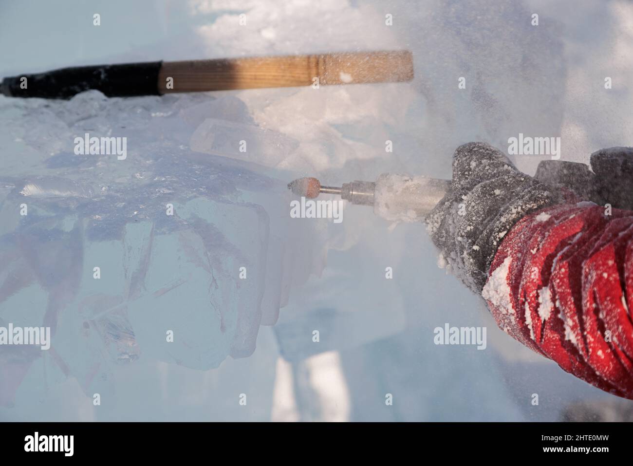 Un uomo taglia il ghiaccio con un attrezzo speciale Foto Stock