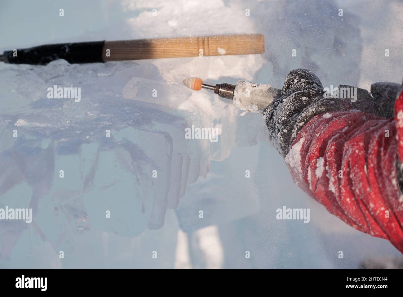 Un uomo taglia il ghiaccio con un attrezzo speciale Foto Stock