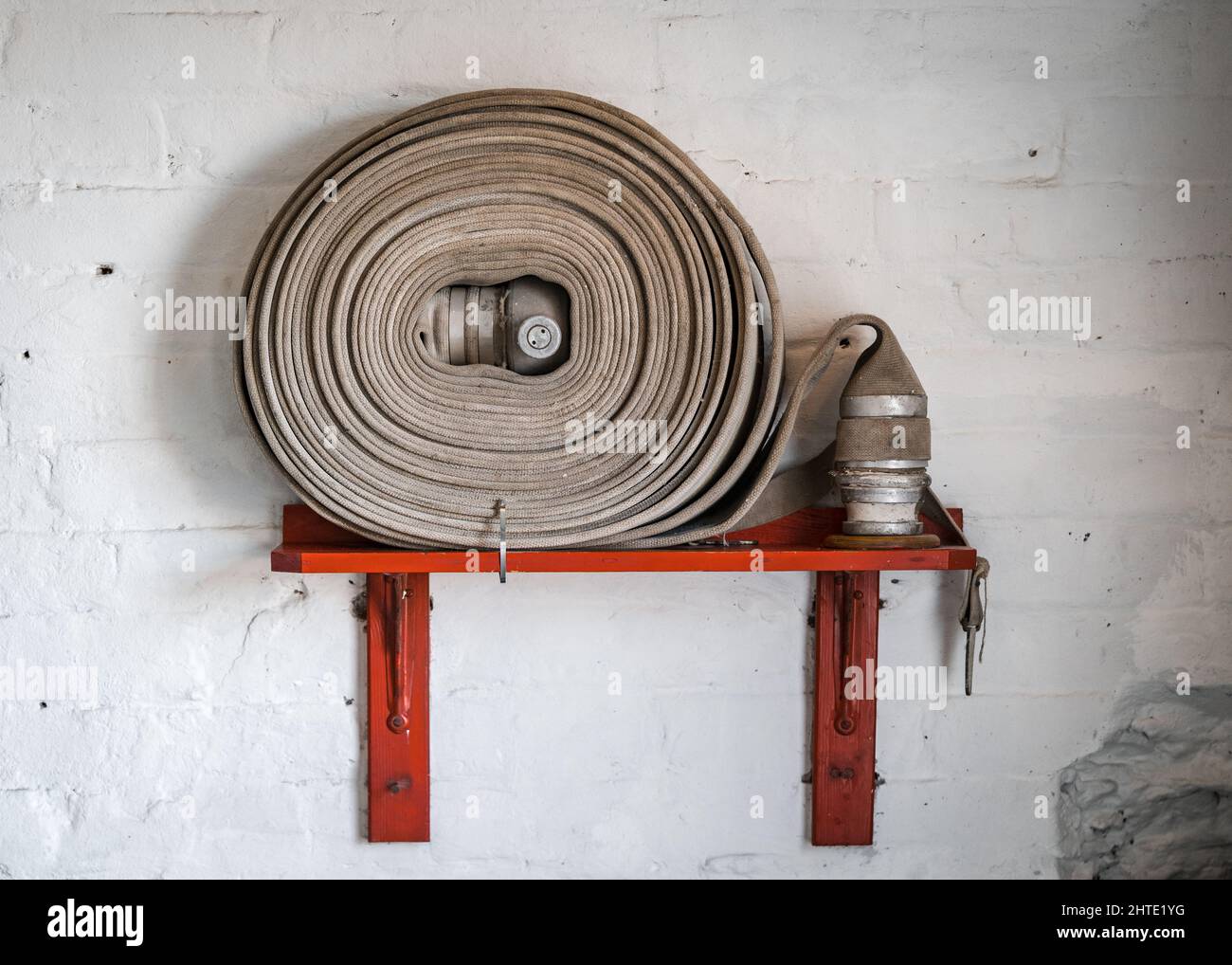 Vecchio stile casa di fuoco sulla parete del magazzino retrò mulino di affari. Raccordo in ottone e tubo in materiale. Foto Stock