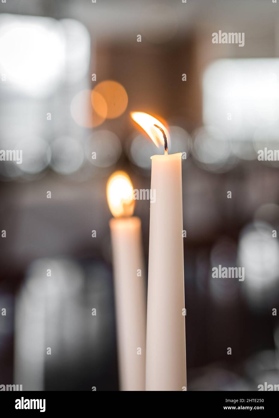 Candela illuminata e bruciante al tavolo da pranzo romantico per in coppia d'amore. Due candele con fiamma arancione. Festa a lume di candela. Foto Stock