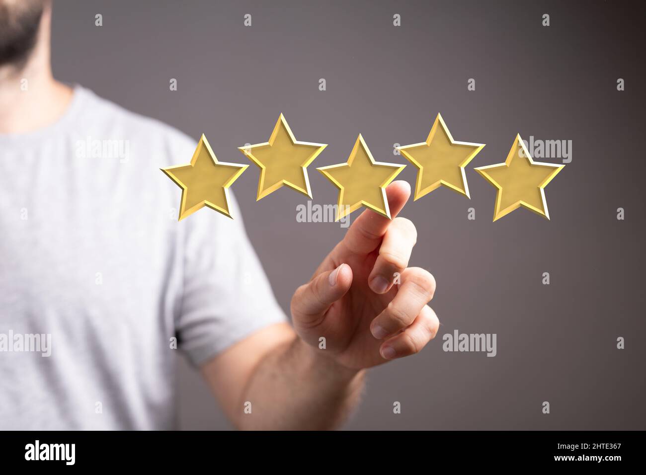 Maschio che punta ai simboli a cinque stelle per aumentare il rating dell'azienda Foto Stock