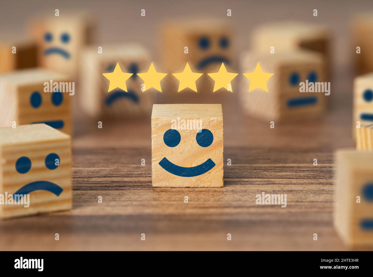 Raccolta a mano sorridente fronte cubo di legno e 5 stelle. Simbolo di revisione e valutazione del servizio clienti. Feedback sulla soddisfazione del cliente, sondaggio. Foto Stock