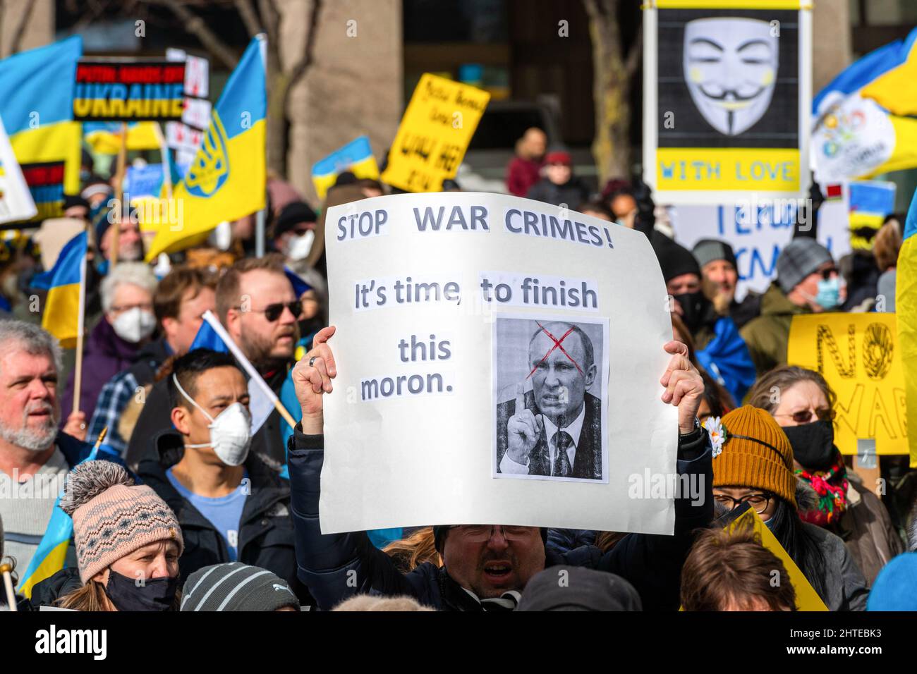 Toronto, Canada - 27 febbraio 2022: Un segno anti Putin recita: 'Fine dei crimini di guerra, è tempo di finire questo morone?. Un segno anonimo in background Foto Stock