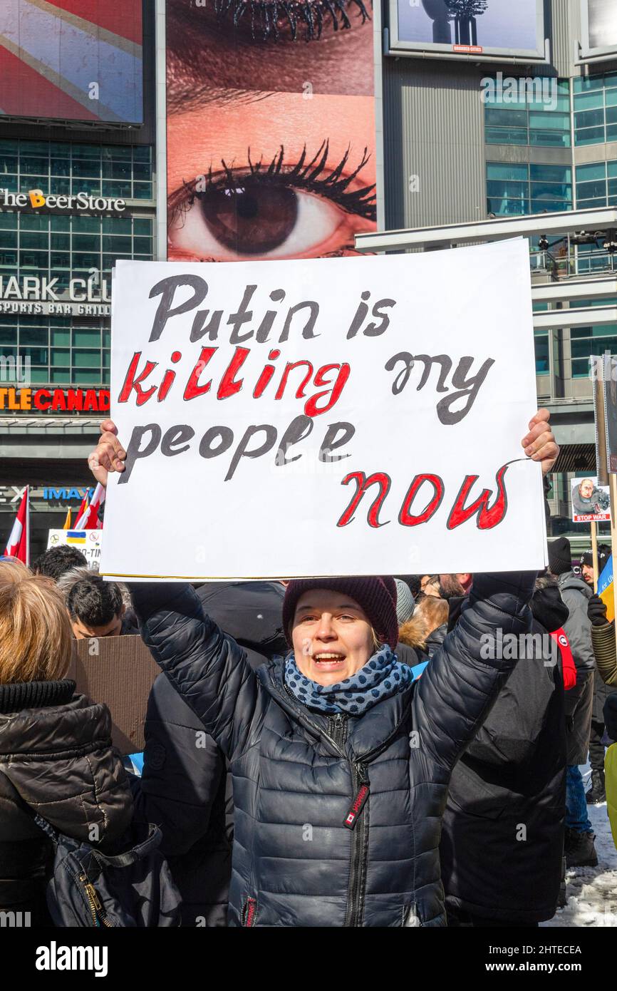 Toronto, Canada - 27 febbraio 2022: Una donna protesta urlando e tenendo un cartello con la scritta "Putin sta uccidendo il mio popolo”. Il raduno a sostegno dell'Ucraina Foto Stock