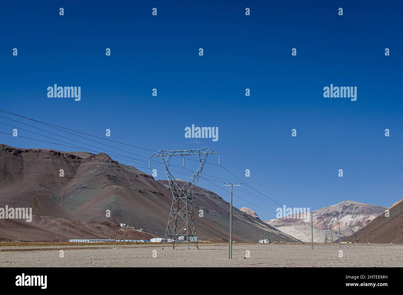 Una strada autostradale e torre elettrica lungo le Ande nel nord del Cile, vicino alla miniera di Maricunga a 3000 metri sul livello del mare Foto Stock