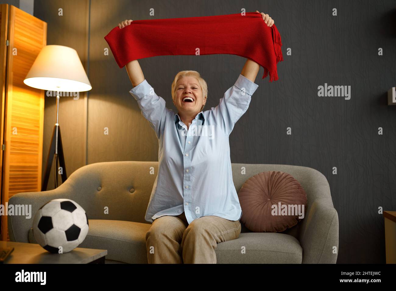 Football anziano e gioioso che tiene la sciarpa sopra la testa Foto Stock