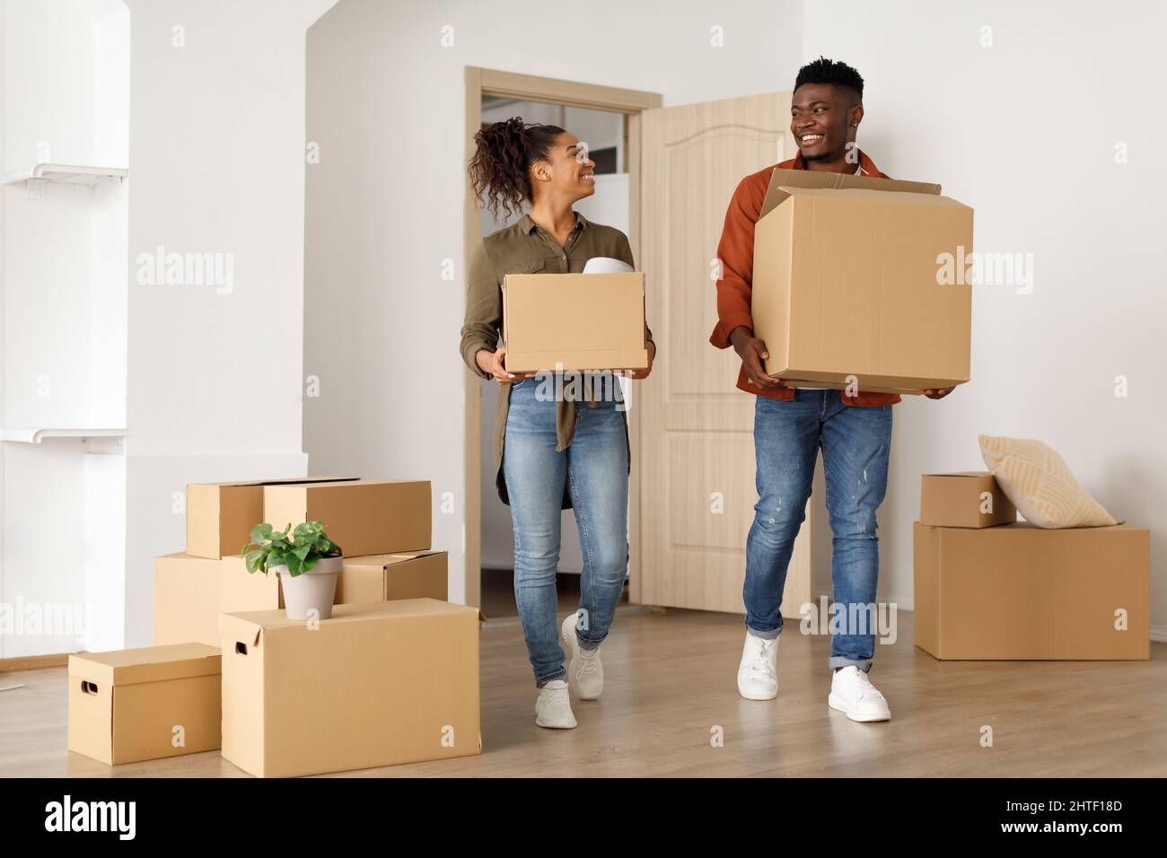 I coniugi africani che trasportano le scatole mobili che entrano nella loro propria casa Indoor Foto Stock