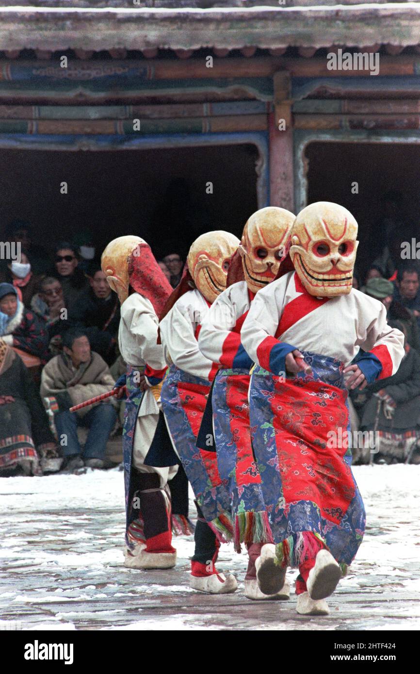 I ballerini tibetani dello scheletro del Ging in maschere craniche eseguono la danza Cham durante le celebrazioni del Monlam che segnano il nuovo anno tibetano al monastero di Kumbum, noto anche come monastero Ta'er, 12 febbraio 1990 a Lusar, Xining, Qinghai, Cina. Foto Stock