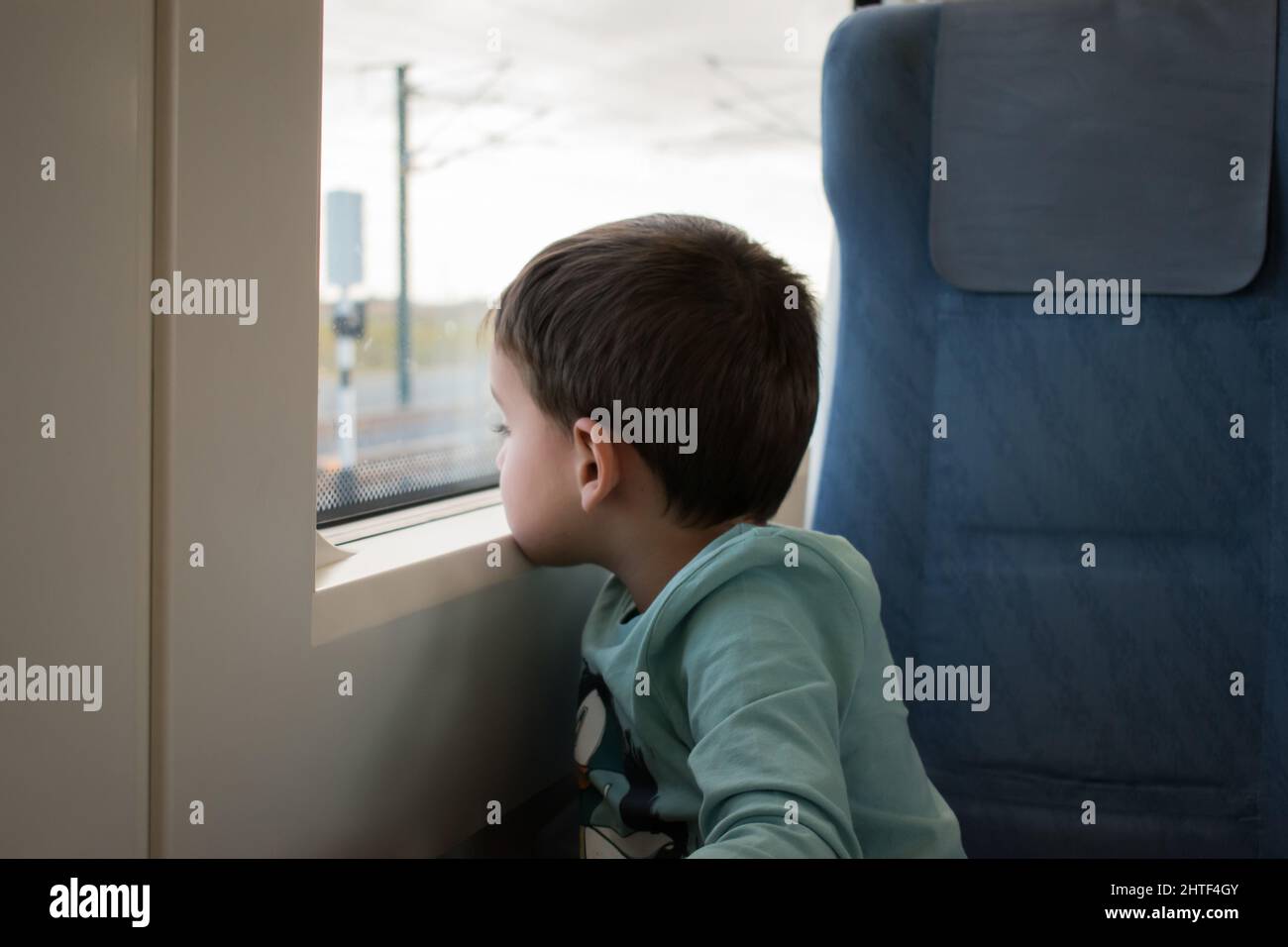 Ragazzo del bambino che osserva fuori finestra del tram o del