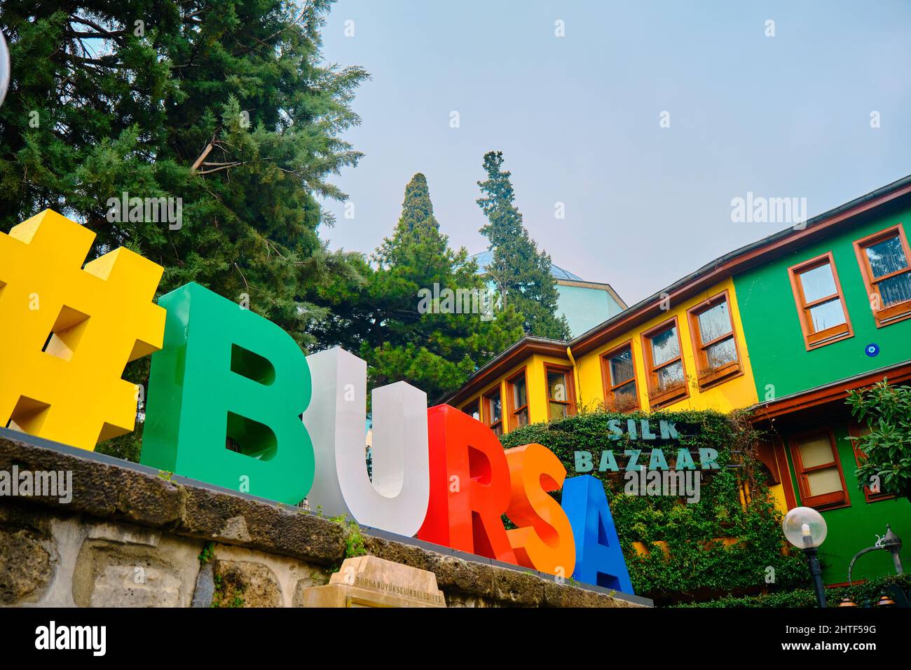 29.03.2021. Bursa.Turchia. Lettere ad angolo basso di 'Bursa', antiche case di architettura ottomana e mausoleo sfondo verde nome locale è yesil turbe. Foto Stock