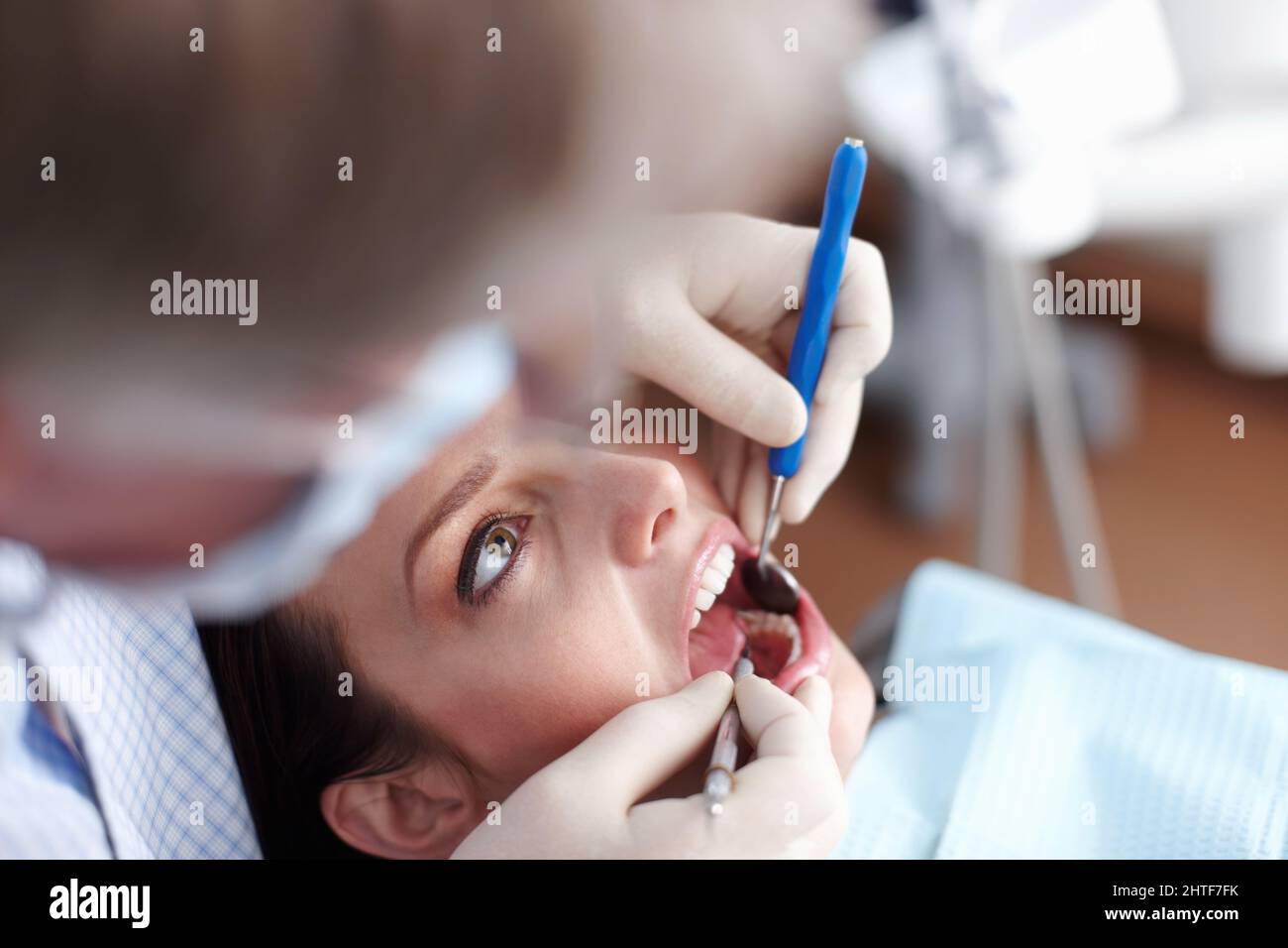 Paziente che visita il dentista. Vista ad angolo elevato del dentista che controlla i denti del paziente. Foto Stock